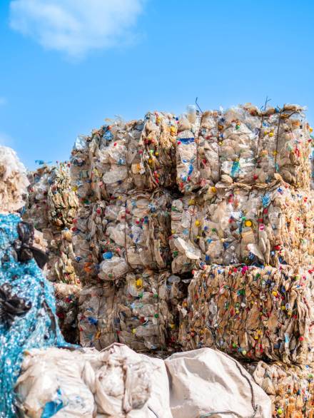 Multiple cubes of compressed plastic garbage near the waste recycling factory in open air