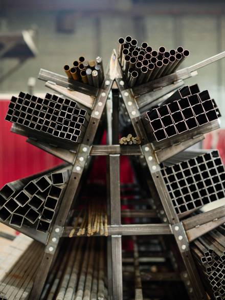 Vertical image of finished metal materials different diameters lying on pallet in workshop